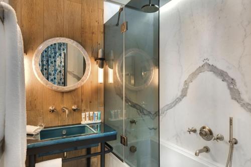 a bathroom with a shower and a sink and a mirror at La Demeure Montaigne in Paris