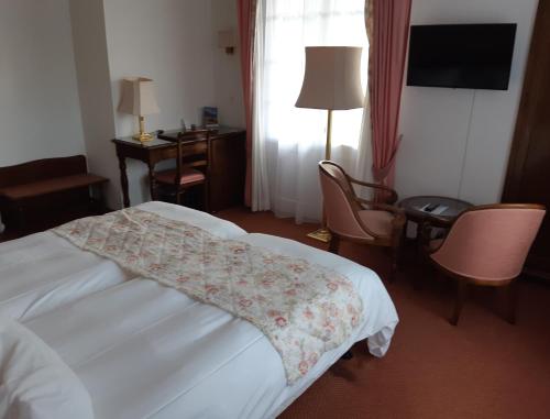 a hotel room with a bed and a table and chairs at Hotel Regina in Wengen