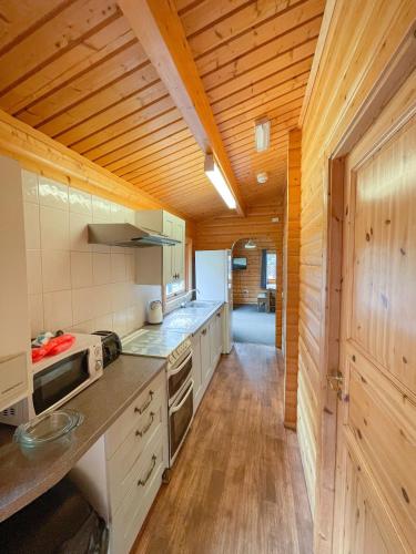 a kitchen with wooden walls and a wooden floor at Avon Tyrrell Outdoor Activity Centre in Bransgore