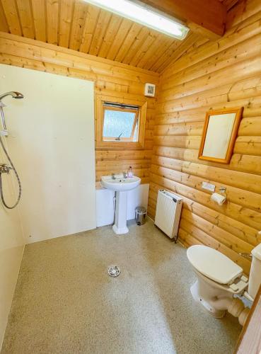 a bathroom with a white sink and a toilet at Avon Tyrrell Outdoor Activity Centre in Bransgore