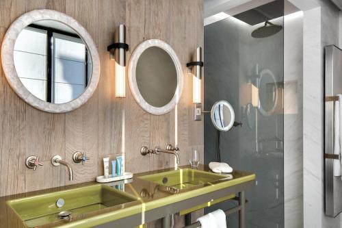 a bathroom with a green sink and a mirror at La Demeure Montaigne in Paris
