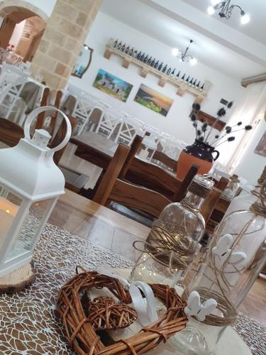 a table with many glass vases and a basket on it at Hotel Salento in Specchia
