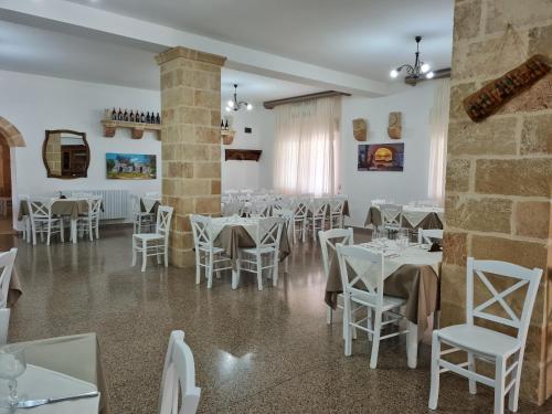a dining room with white tables and white chairs at Hotel Salento in Specchia