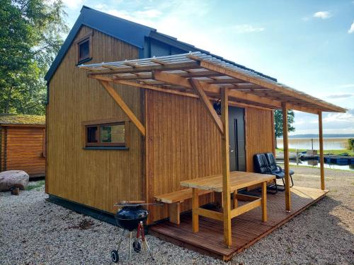 a tiny house with a table and a desk at Tõhela Järve Puhkeküla in Männikuste