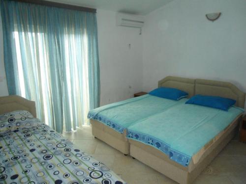 sypialnia z 2 łóżkami i niebieskimi poduszkami w obiekcie Apartments Pekic w Barze