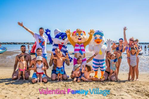 a group of people posing for a picture on the beach at Hotel Rosalba - Valentini Family Village in Bellaria-Igea Marina
