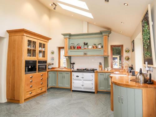 a large kitchen with green cabinets and counters at Eagle Farmhouse in Glenridding
