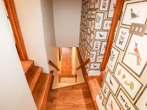 a staircase in a house with art on the walls at Eagle Farmhouse in Glenridding