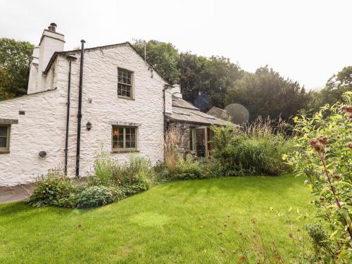 an old white stone house with a yard at Eagle Farmhouse in Glenridding