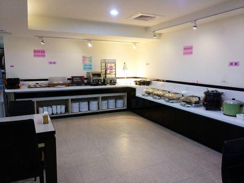 un restaurante cocina con barra con comida en Kaishen Hotel en Taitung