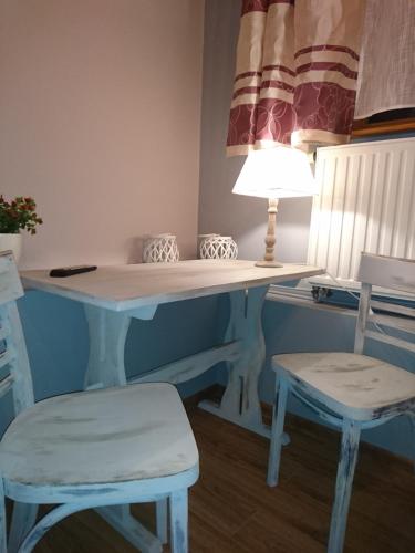 a desk with two chairs and a table with a lamp at NOCLEGI POD STODOŁĄ in Kraków