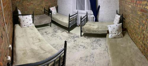 a room with three beds and a brick wall at Kolsay Aisha in Saty