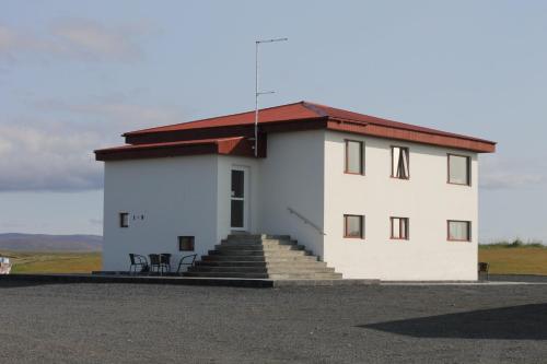 a white building with stairs and a red roof at Holssel road 864 in Myvatn