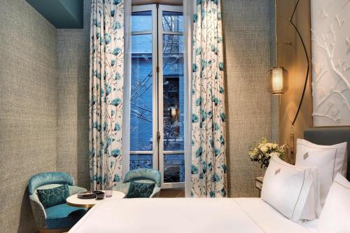 a hotel room with a bed and a window at La Demeure Montaigne in Paris