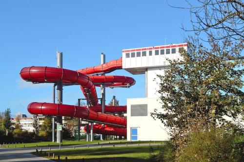 uno scivolo d'acqua rosso di fronte a un edificio di Studios im Ferien- und Freizeitpark Weissenhäuser Strand, Weissenhäuser Strand a Weissenhäuser Strand