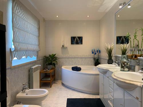 uma casa de banho com uma banheira, 2 lavatórios e um WC. em The Sweet Dreams Holiday House em Azeitao