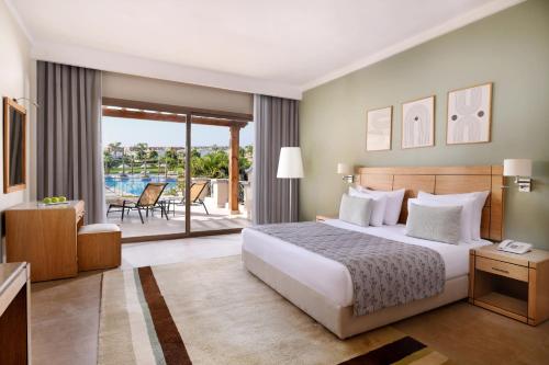 a hotel room with a bed and a balcony at JAZ Little Venice Golf Resort in Ain Sokhna
