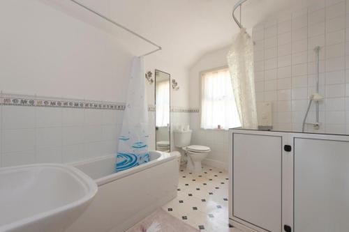 a white bathroom with a tub and a toilet at The Mount 3 Bedroom Relaxation Home in Chatham
