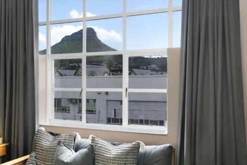 a large window with a couch in front of it at Studio on Hope by HostAgents in Cape Town