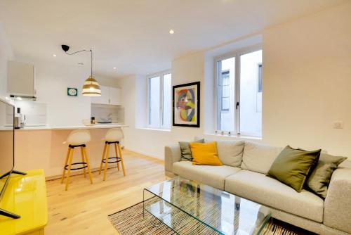 un salon avec un canapé et une table en verre dans l'établissement Le Cachet de la Craffe - Au cœur de Nancy, à Nancy