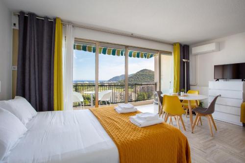 sypialnia z dużym łóżkiem i stołem z krzesłami w obiekcie Cannes Marina suite vue mer w mieście Mandelieu-la-Napoule