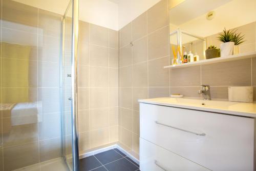 W łazience znajduje się umywalka i prysznic. w obiekcie Cannes Marina suite vue mer w mieście Mandelieu-la-Napoule