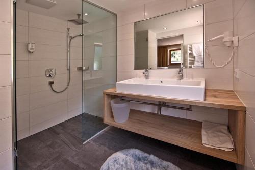 a bathroom with a sink and a shower at Landhotel Denggerhof in Mayrhofen