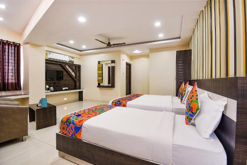 una camera da letto con due letti e un soggiorno di FabHotel Rotano Suites - Yelahanka a Bangalore