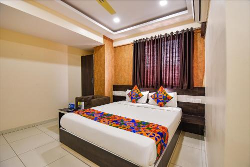 a bedroom with a large bed and a window at FabHotel Rotano Suites Yelahanka in Bangalore