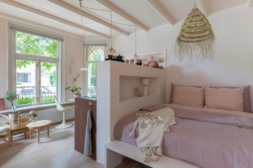 um quarto com uma cama roxa num quarto com janelas em Magnolia Spring Boutique Apartments em Bergen