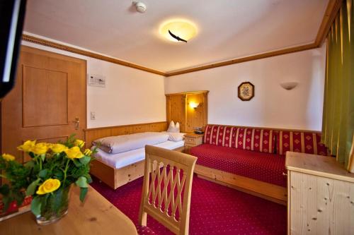a hotel room with a bed and a table with flowers at Landhotel Denggerhof in Mayrhofen
