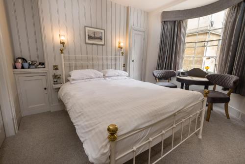 a bedroom with a bed and a desk and a window at Crown Hotel in Stamford