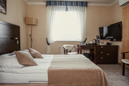 a hotel room with a bed and a window at Hotel Aurora Family & SPA in Międzyzdroje
