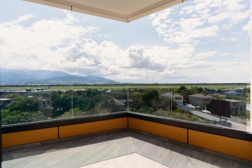 a room with a large window with a view of a city at Cozy Loft Hotel in Batumi