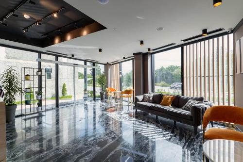 a living room with a couch and some windows at Cozy Loft Hotel in Batumi