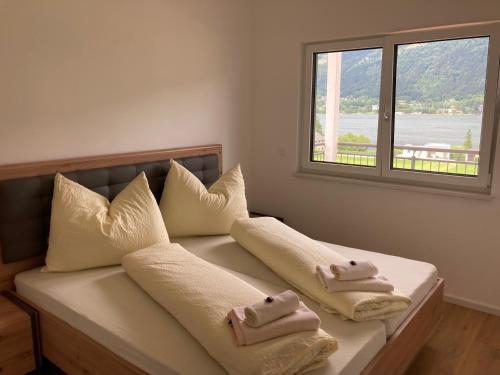 a bed with towels on it with a window at Pension Neuhof in Ossiach