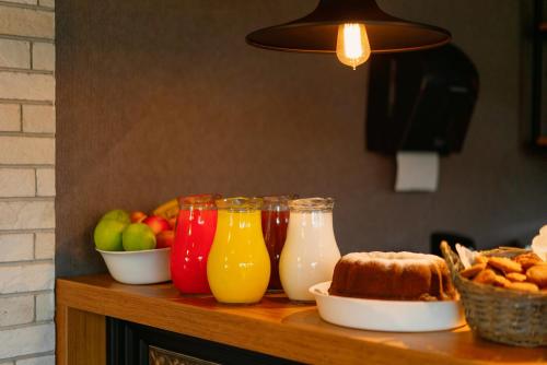 a table topped with glasses of juice and fruit at Cozy Loft Hotel in Batumi