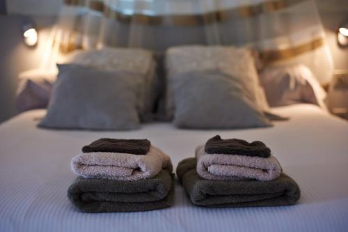 a pile of towels sitting on top of a bed at Logis Hôtels Troglododo in Azay-le-Rideau