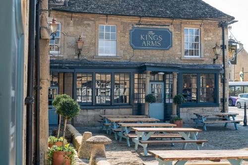 a row of wooden tables in front of a building at The Kings Arms Hotel in Melksham