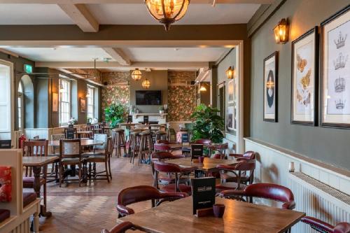 a restaurant with tables and chairs in a room at The Kings Arms Hotel in Melksham