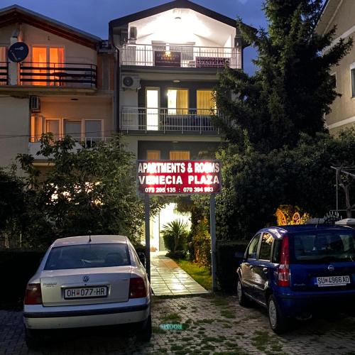 two cars parked in a parking lot in front of a building at Venecia Plaza Struga in Struga