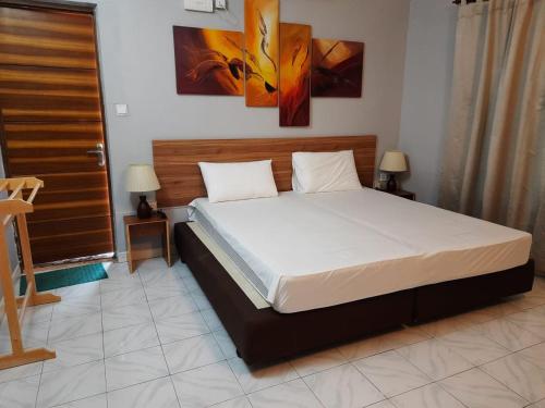 a large bed in a room with two tables and two lamps at Royal Beach Dhigurah in Dhigurah