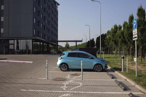 a small blue car parked in a parking lot at Park Inn by Radisson Vilnius Airport Hotel & Conference Centre in Vilnius