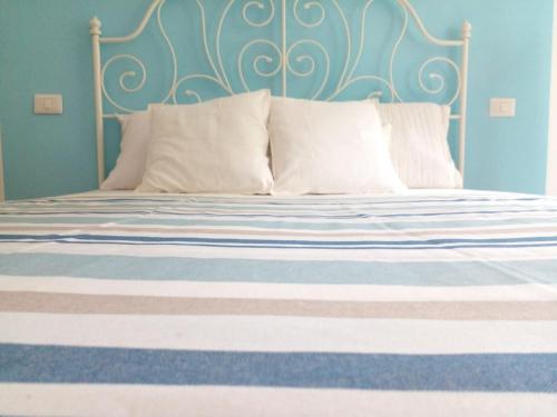 a bed with a blue head board and white pillows at CASA ADRI. Comoda, accessibile, luminosa. in Vernazza