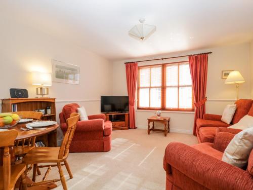 a living room with red furniture and a table at Derwent Haven in Keswick