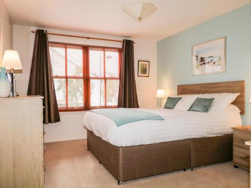 a bedroom with a bed and a large window at Derwent Haven in Keswick