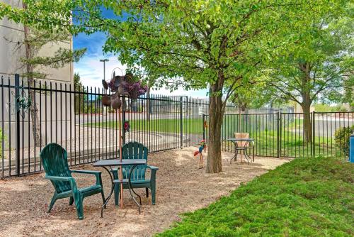 a park with two chairs and a table and a tree at Days Inn & Suites by Wyndham Airport Albuquerque in Albuquerque