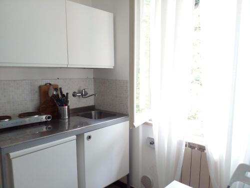 a kitchen with white cabinets and a sink and a window at CASA ADRI. Comoda, accessibile, luminosa. in Vernazza