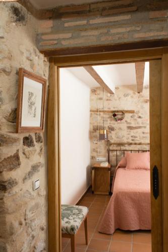 a bedroom with a bed in a stone wall at LA MIMBRERA in Estercuel