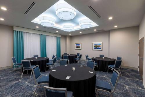 a conference room with round tables and blue chairs at La Quinta Inn & Suites by Wyndham Round Rock near Kalahari in Round Rock